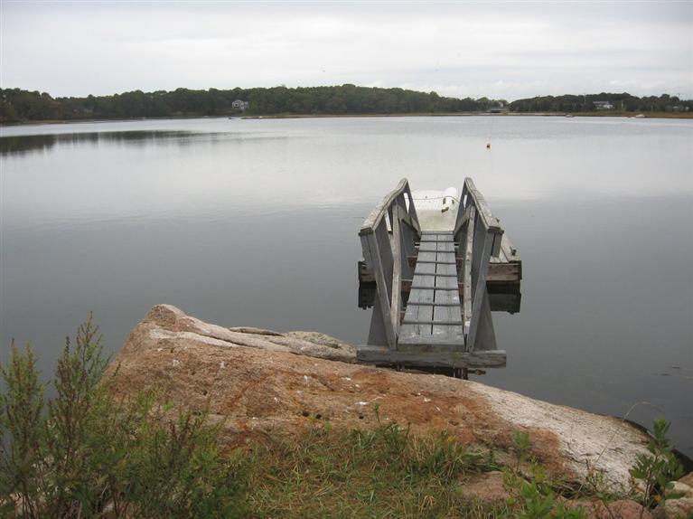 80 Old Dam Road Bourne, MA 02532 - Photo 25 of 31 a view of a lake with a bench and lake view