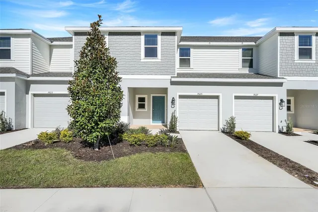 a front view of a house with a yard and garage