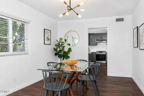 a dining room with furniture potted plants and wooden floor