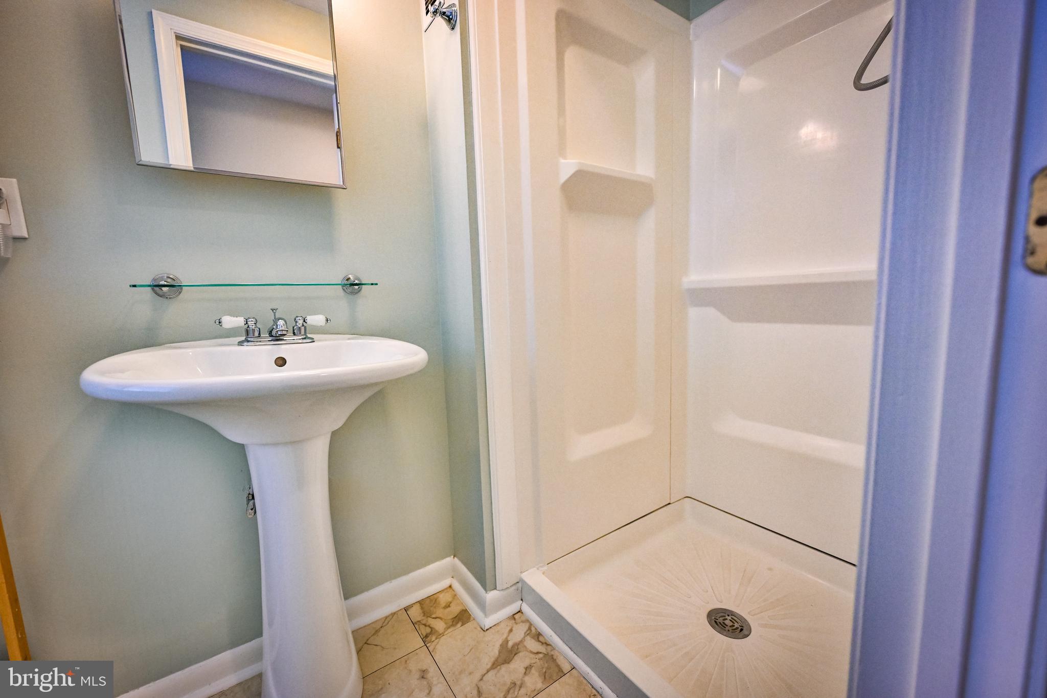 1601 Marshall Street Baltimore, MD 21230 - Photo 20 of 32 a bathroom with a sink a mirror and a shower