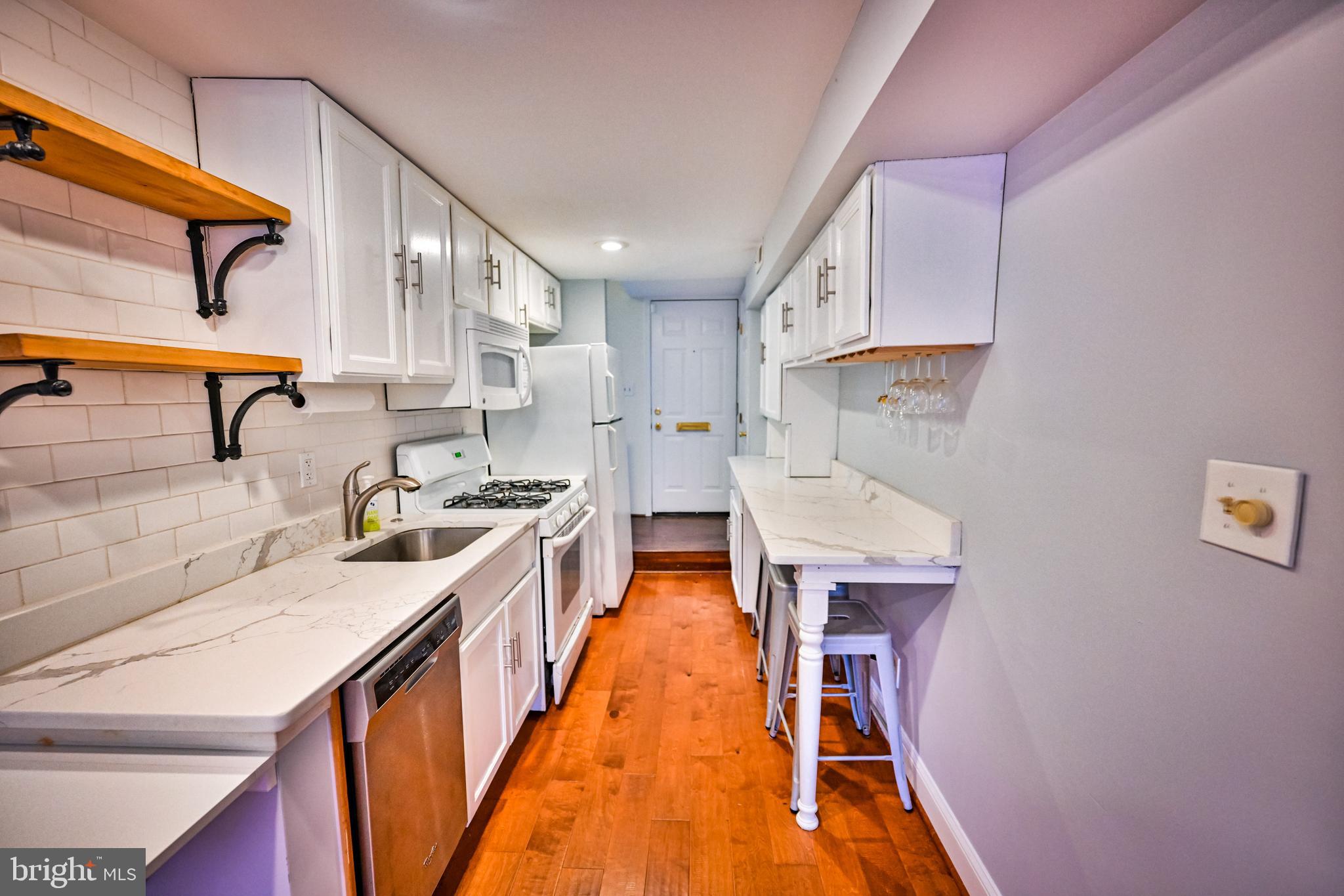 1601 Marshall Street Baltimore, MD 21230 - Photo 7 of 32 a kitchen with stainless steel appliances granite countertop a sink a stove and a wooden floors