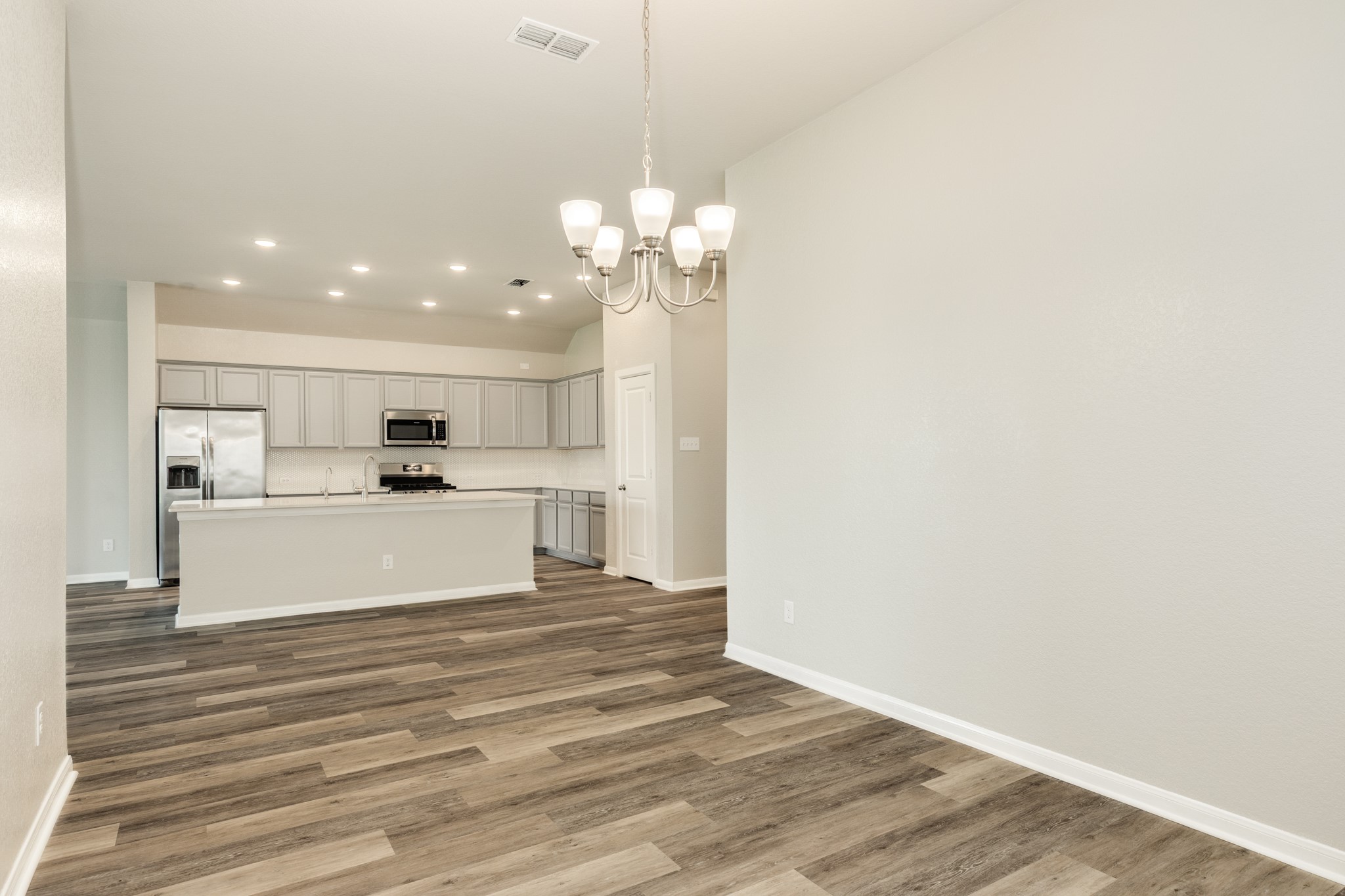 4946 Hitchings Court Rosharon, TX 77583 - Photo 47 of 49 This view showcases the property's open floor plan, highlighting the smooth transition between the dining area, kitchen, and family room, creating a welcoming and functional living space.