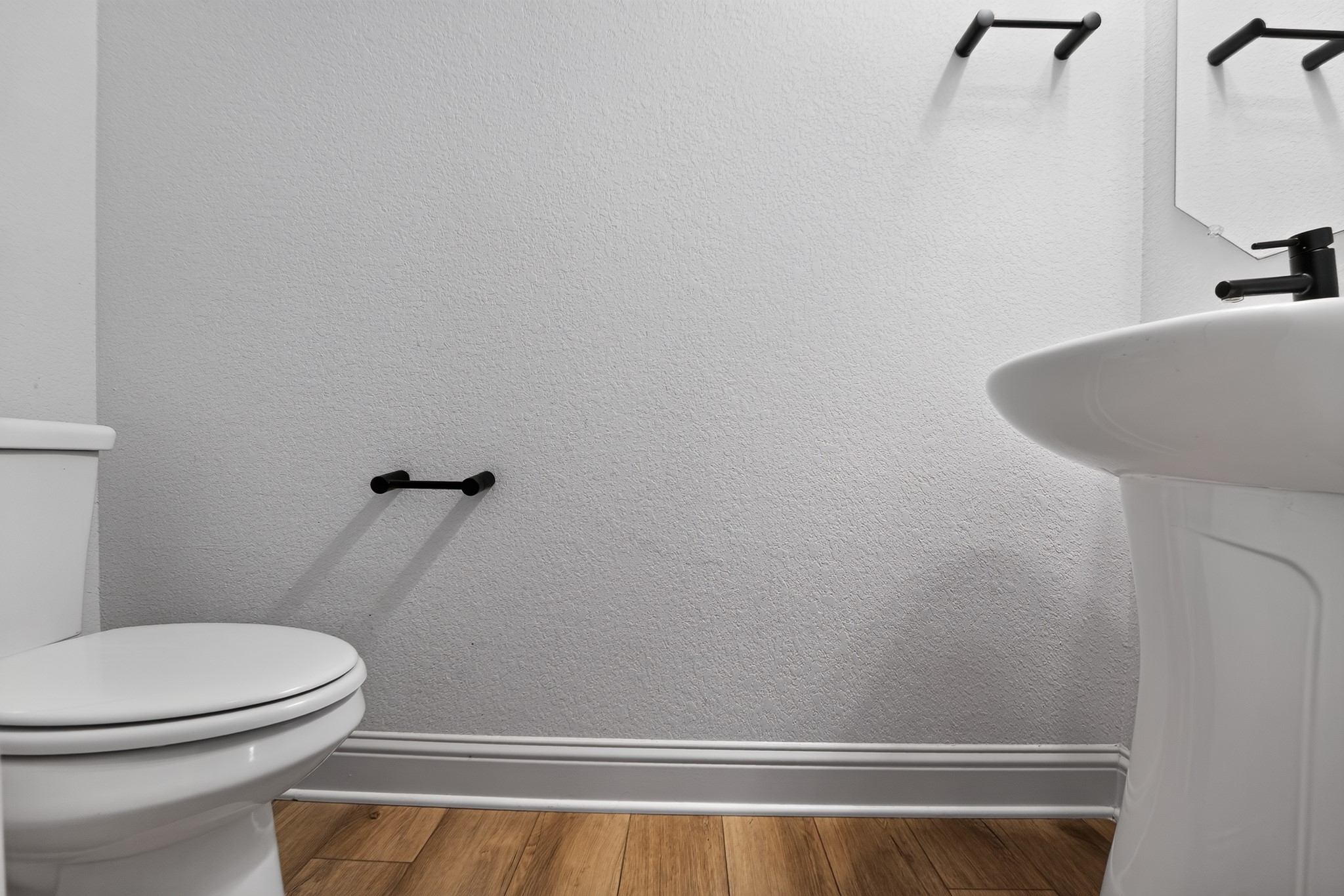 508 Pinnacle View Drive Georgetown, TX 78628 - Photo 20 of 27 Hardwood-style flooring extends below a contemporary pedestal sink and clean-lined commode.