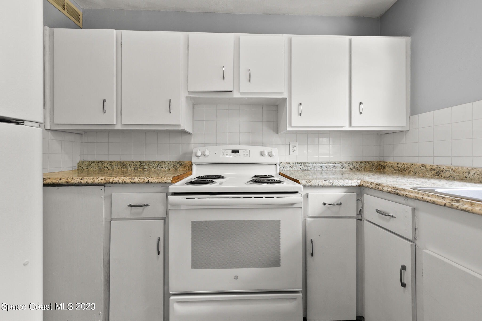 650 Dixon Boulevard, Unit B4 Cocoa, FL 32922 - Photo 12 of 21 a kitchen with granite countertop white cabinets and white appliances