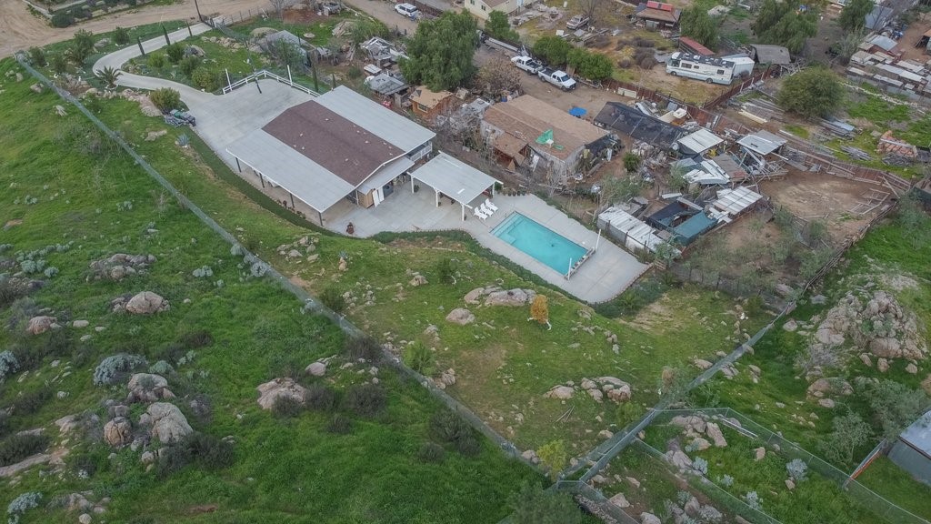an aerial view of residential house with outdoor space and trees all around