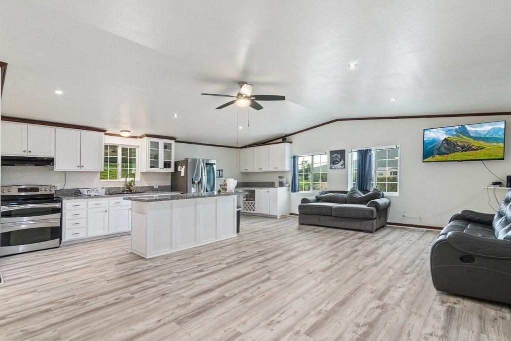 26460 Dale Street Hemet, CA 92545 - Photo 27 of 40 a kitchen with stainless steel appliances kitchen island granite countertop a stove and white cabinets with wooden floor