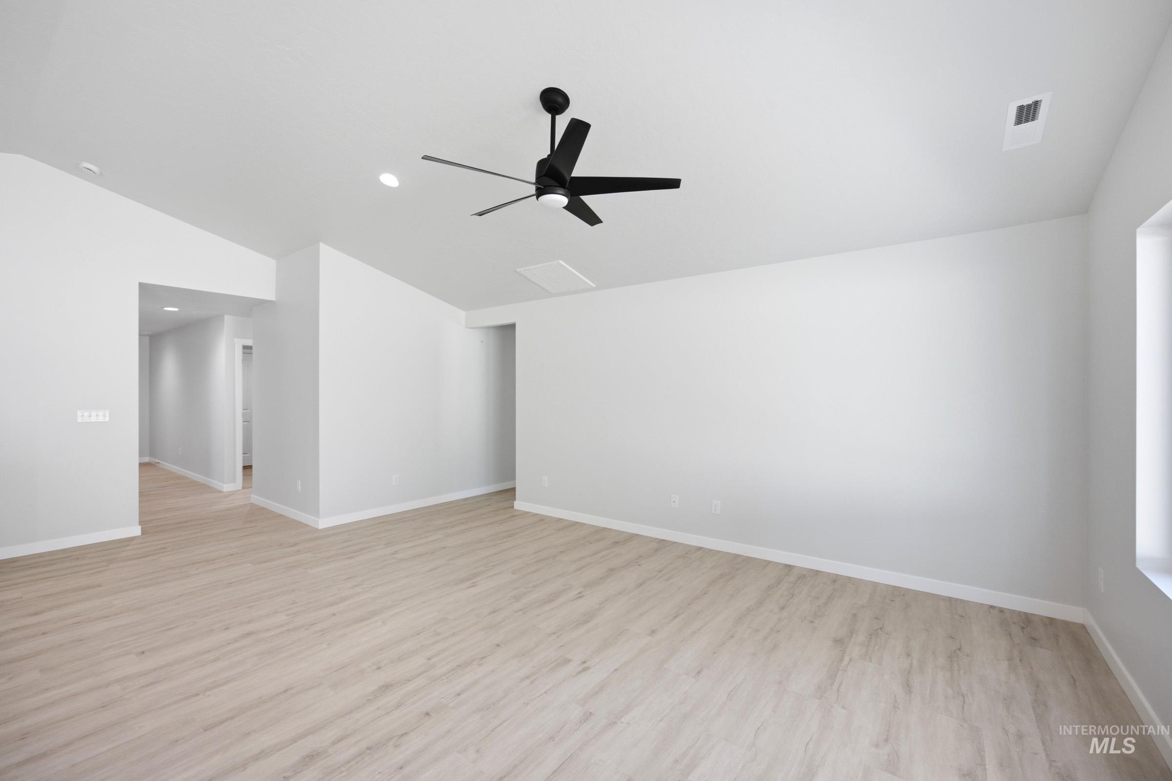 13298 Bank Street Caldwell, ID 83607 - Photo 8 of 23 Spacious interior with high ceilings, recessed lighting, a modern black ceiling fan, wood-finish flooring, and natural light from a window