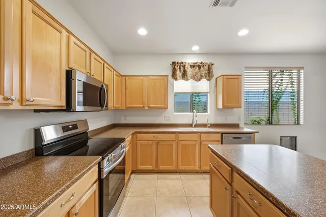 a kitchen with stainless steel appliances granite countertop a sink stove microwave and cabinets