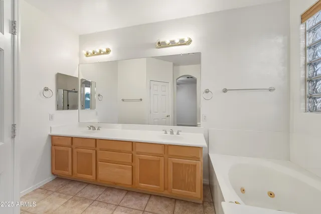 a bathroom with a tub sink and mirror