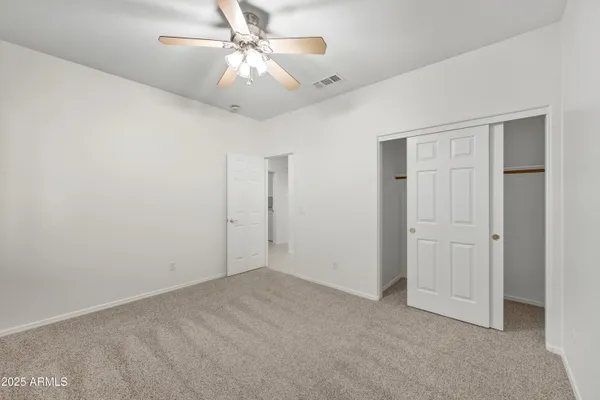 an empty room with a ceiling fan and a window