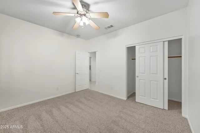 an empty room with a ceiling fan and a window