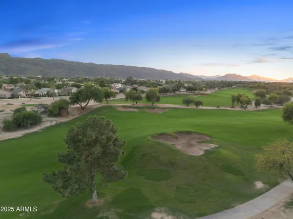 a view of a lush green outdoor space with a lake view