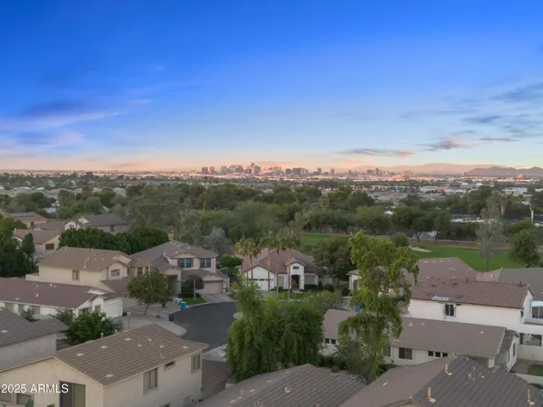 an aerial view of residential houses with outdoor space and trees