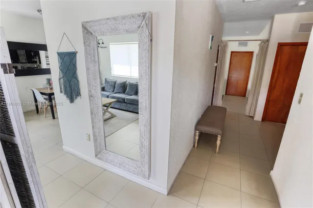 a view of a hallway and a livingroom with furniture