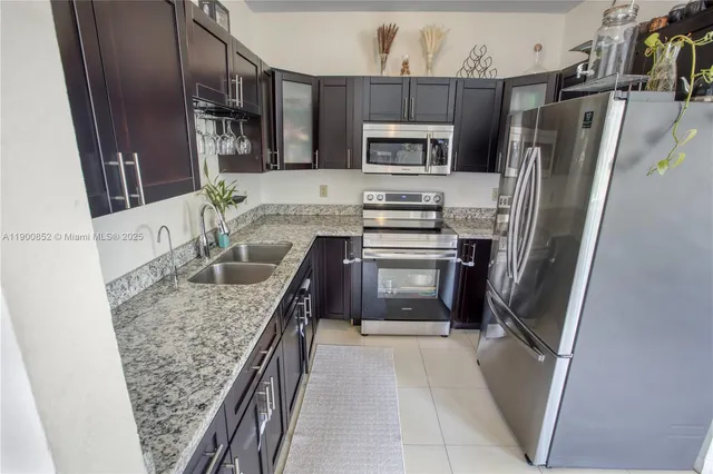 a kitchen with stainless steel appliances granite countertop a refrigerator and a sink