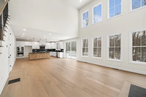 a view of an empty room with kitchen appliances and windows