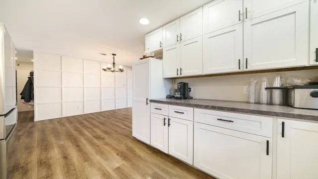 a kitchen with granite countertop white cabinets and stainless steel appliances