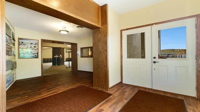 a view of a hallway with wooden floor and windows