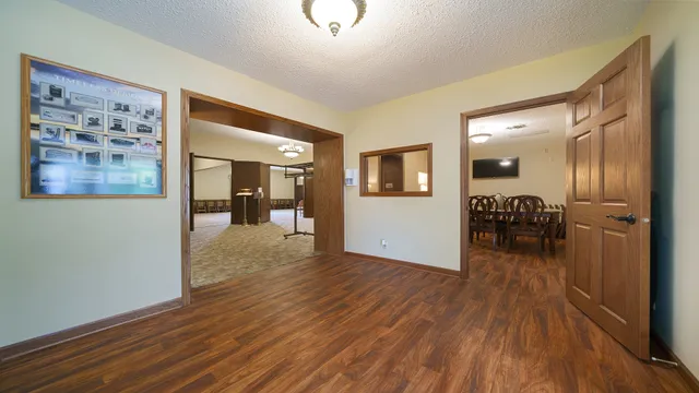 a view of a hallway view with wooden floor and a living room