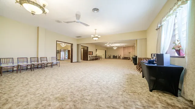 a living room with furniture and a dining table with floor to ceiling window