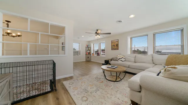 a living room with furniture a lamp and wooden floor