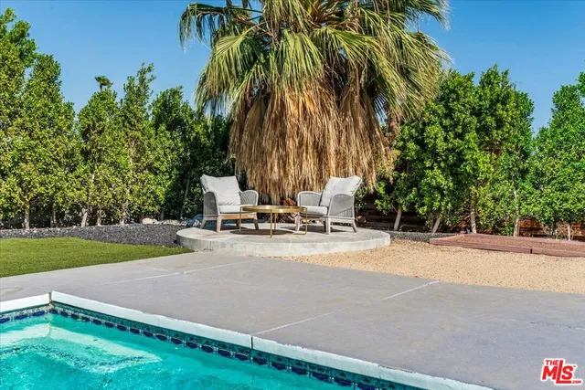 a swimming pool with outdoor seating and yard
