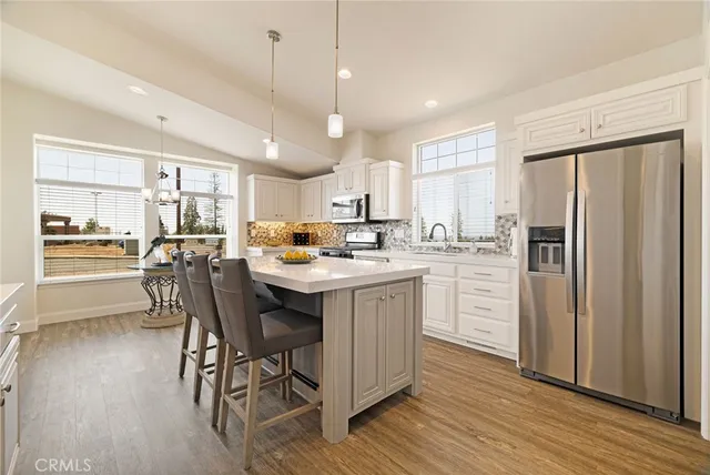 a kitchen with kitchen island granite countertop wooden floors and stainless steel appliances