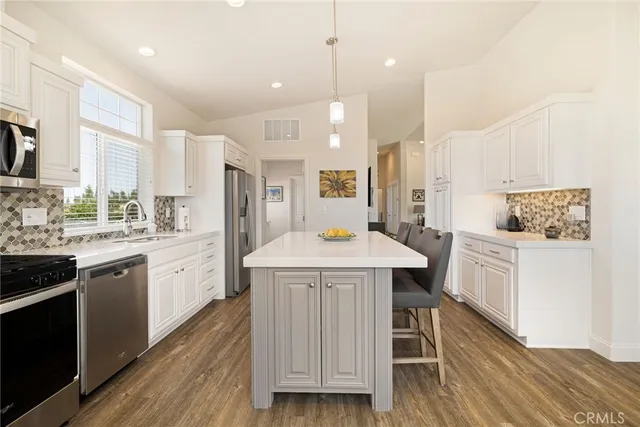 a kitchen with a table chairs sink and cabinets