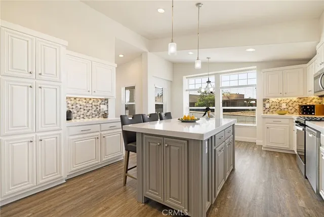 a kitchen with kitchen island granite countertop a sink a counter space appliances and cabinets