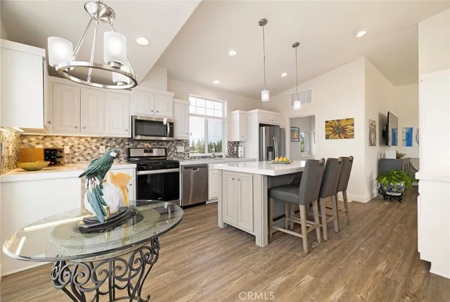 a kitchen with a table chairs refrigerator and microwave