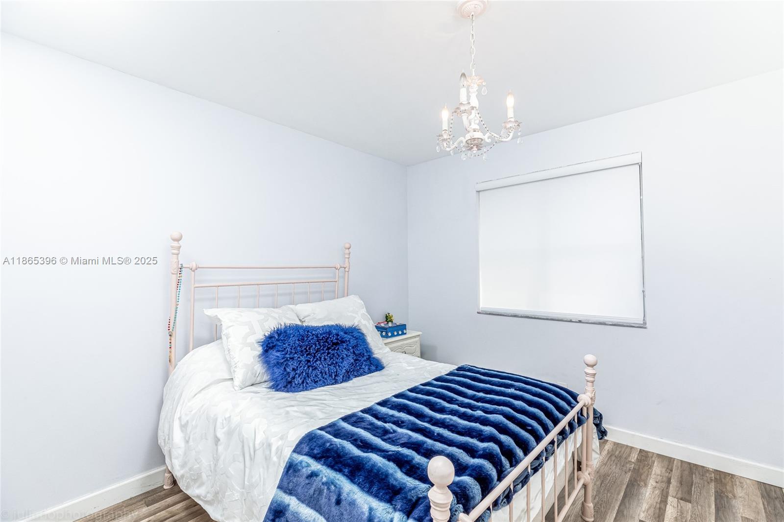 4913 Southwest 32nd Way Hollywood, FL 33312 - Photo 21 of 27 a bedroom with a bed and a chandelier