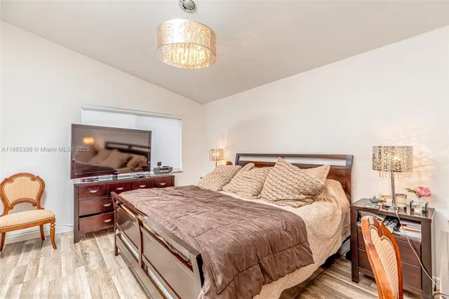 a bedroom with a bed and a chandelier