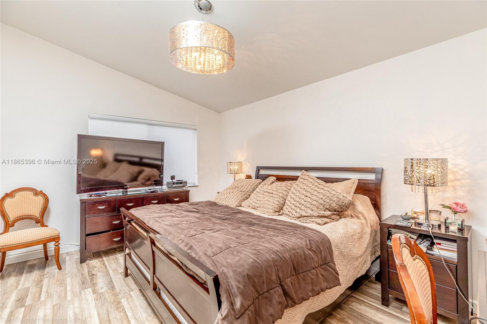 4913 Southwest 32nd Way Hollywood, FL 33312 - Photo 25 of 27 a bedroom with a bed and a chandelier