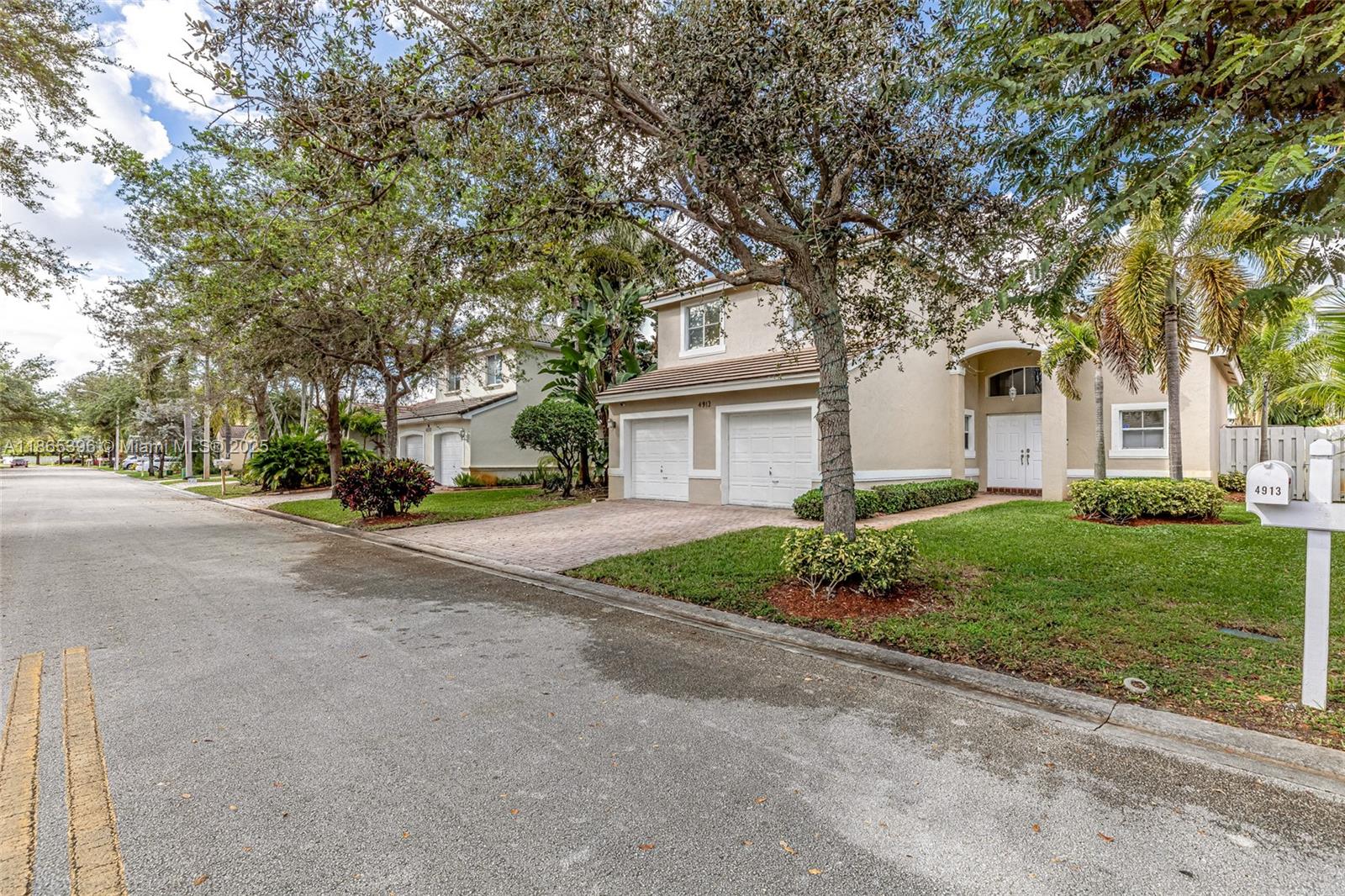 4913 Southwest 32nd Way Hollywood, FL 33312 - Photo 3 of 27 a front view of a house with a garden and trees