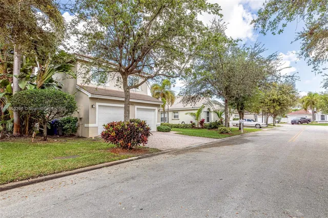 a front view of a house with a garden and trees