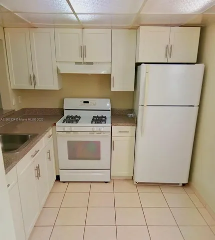 a kitchen with cabinets appliances and a sink