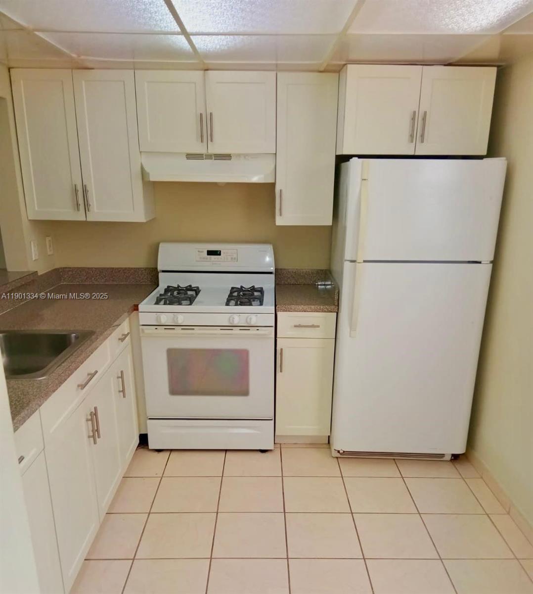 18051 Northwest 68th Avenue, Unit J102 Hialeah, FL 33015 - Photo 1 of 15 a kitchen with cabinets appliances and a sink