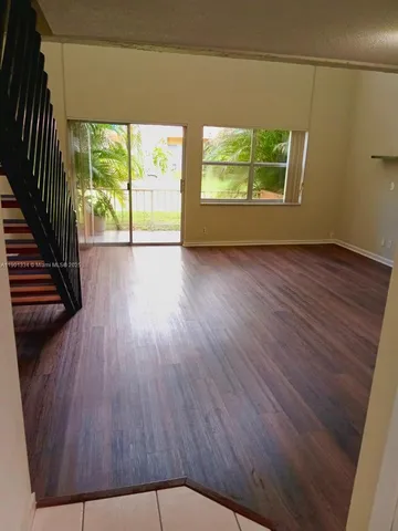 a view of a balcony with a floor to ceiling window and tree