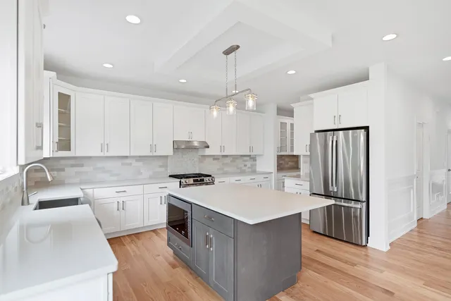 a kitchen with kitchen island a sink stove and refrigerator