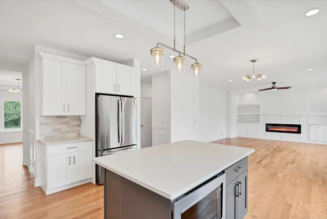 a view of a kitchen with white cabinets and a window