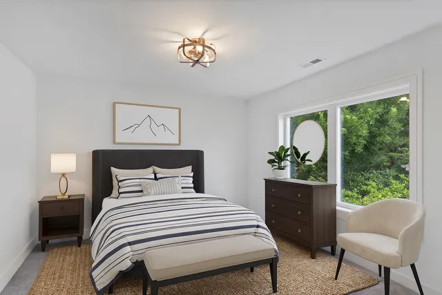 a bedroom with a large bed and a chandelier