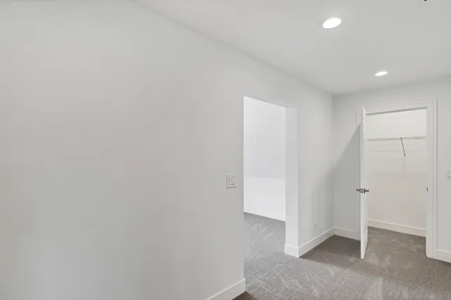 a view of a hallway with wooden floor and a window