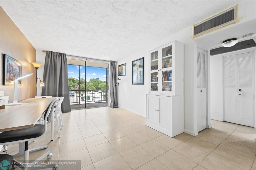 7100 Northwest 17th Street, Unit 218 Plantation, FL 33313 - Photo 3 of 13 a spacious bedroom with a balcony a bed a table and chair