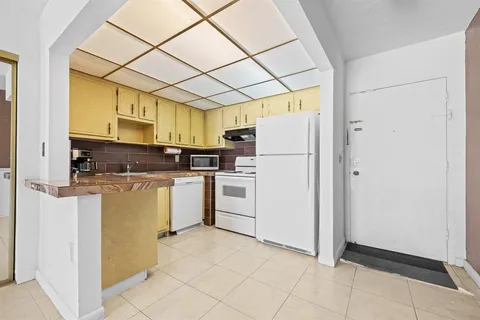 a kitchen with a refrigerator a stove top oven and a dishwasher