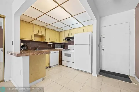 a kitchen with a refrigerator a stove top oven and a dishwasher