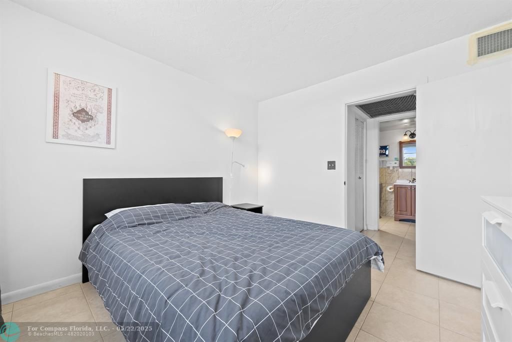 7100 Northwest 17th Street, Unit 218 Plantation, FL 33313 - Photo 9 of 13 a bedroom with a large bed and a chandelier