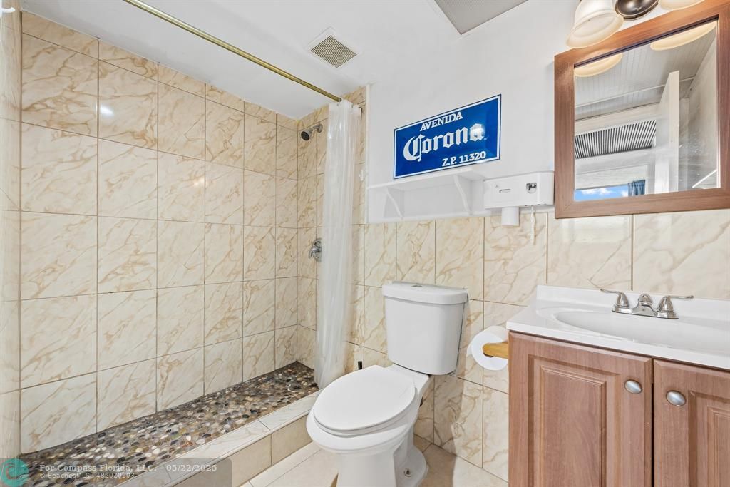 7100 Northwest 17th Street, Unit 218 Plantation, FL 33313 - Photo 10 of 13 a bathroom with a granite countertop toilet a sink and a shower