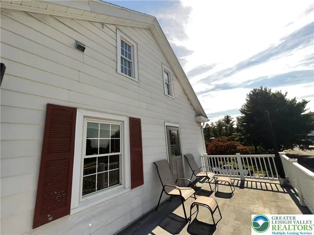 a view of an empty room with wooden floor and stairs