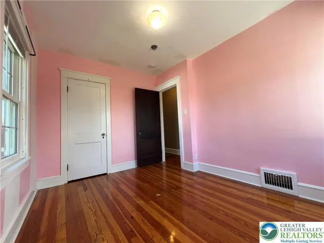 a view of an empty room with wooden floor