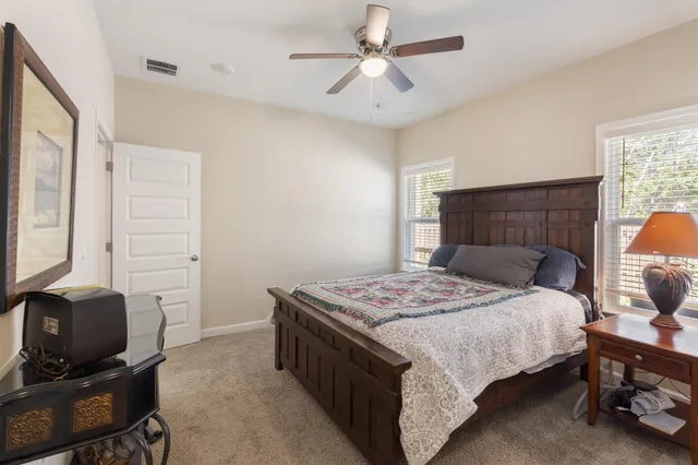 a bedroom with a bed and a table in it with window